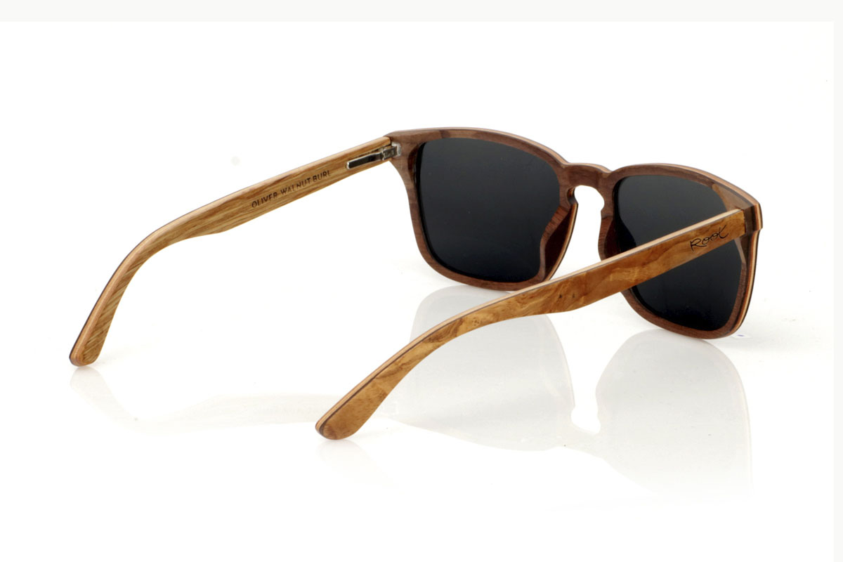 Wood eyewear of Burr OLIVER. OLIVER wooden sunglasses, medium in size and with a square shape with rounded and soft lines, are the perfect balance between design and nature. Made with a careful lamination of olive wood on the outside and interspersed with layers of beech wood, they stand out for the warm color and unique grain that olive wood offers. This combination not only provides exceptional resistance, but also makes each pair a unique piece. With a measurement of 145x47 and a caliber of 53, the OLIVER adapts wonderfully, offering comfort and unmistakable style to those who wear them. Ideal for those looking to stand out with an accessory that speaks of elegance and commitment to the environment. for Wholesale & Retail | Root Sunglasses® 